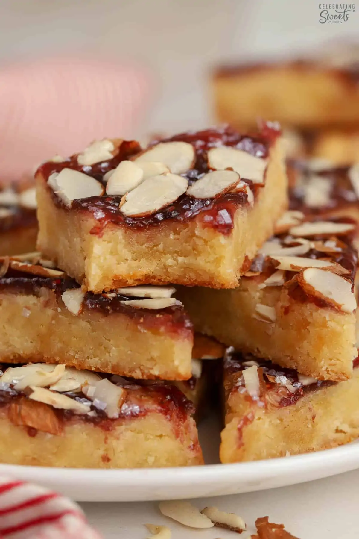 Almond bars cut into triangles on a white plate.