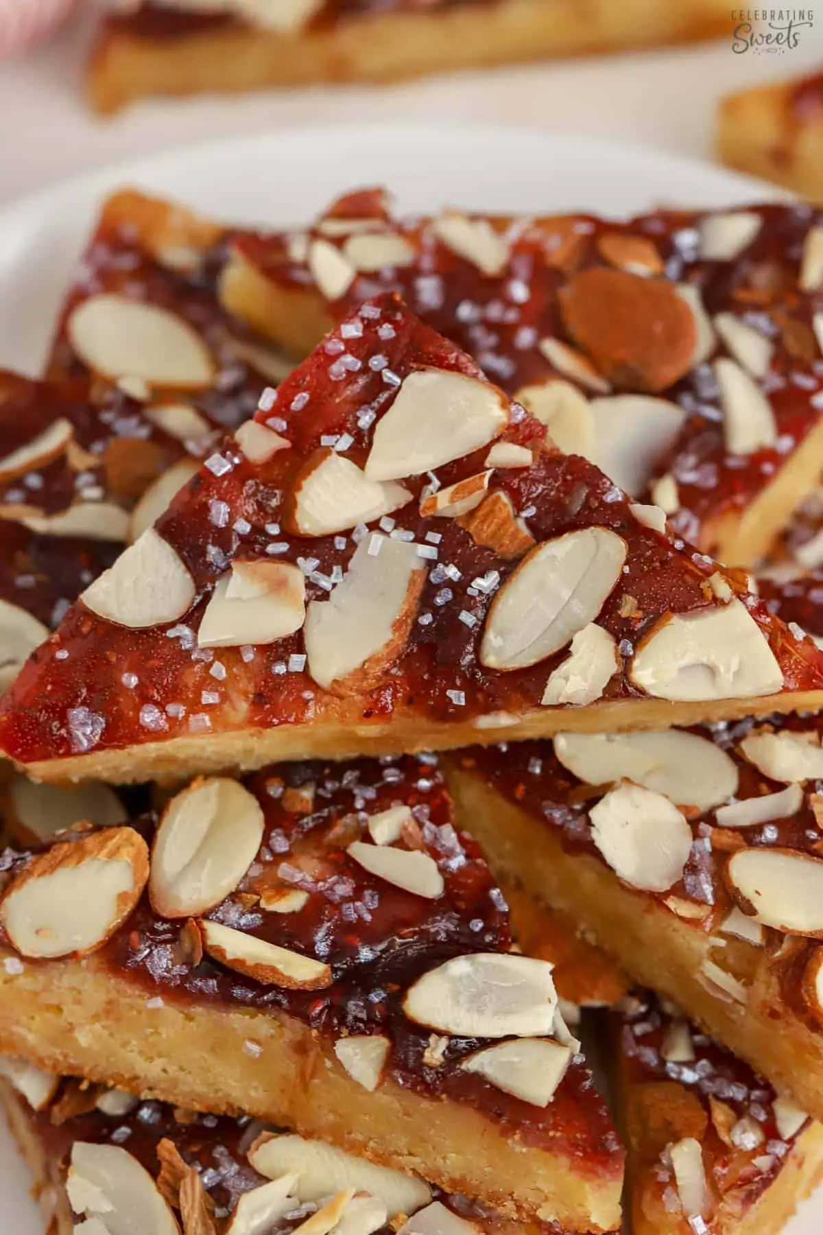 Almond bars cut into triangles on parchment paper.