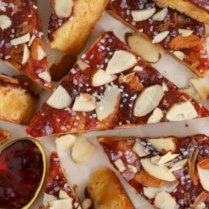 Almond bars cut into triangles on parchment paper.