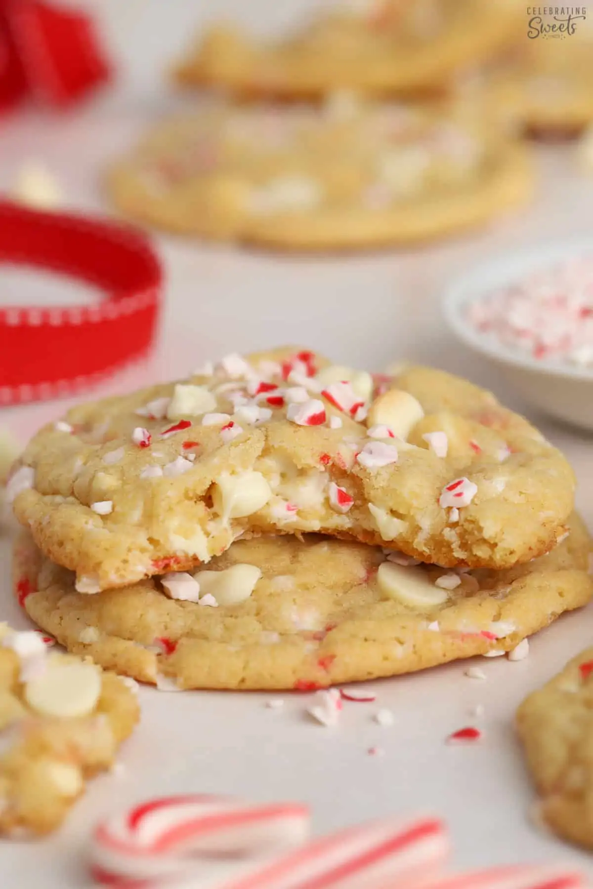 Stack of peppermint cookies next to candy canes.