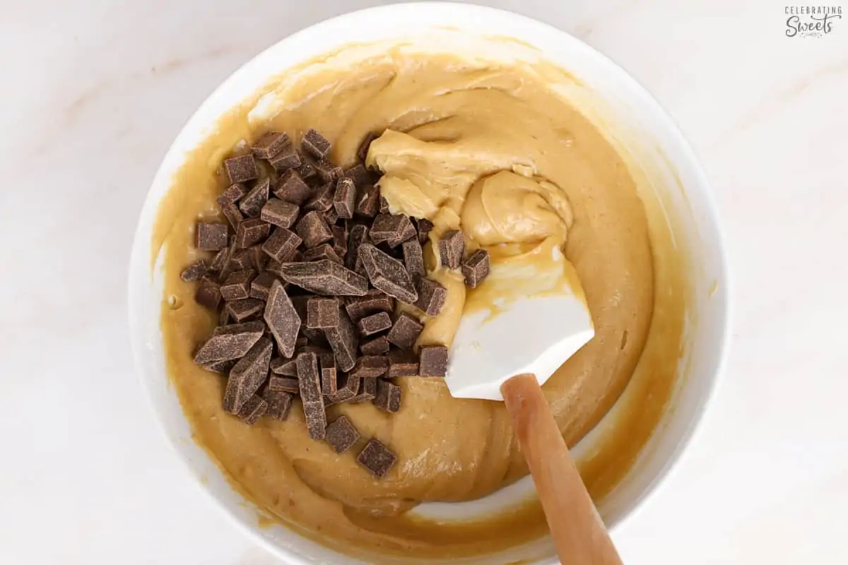 Blondie batter in a white bowl with a rubber spatula.