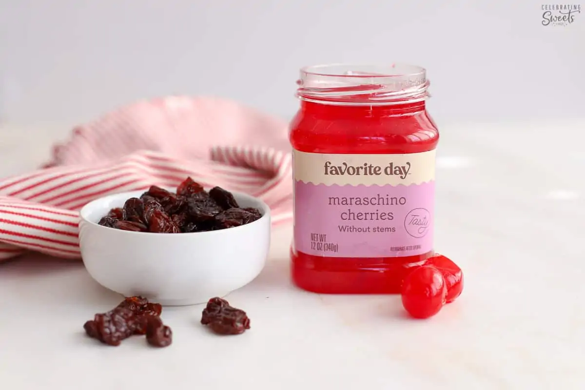Jar of maraschino cherries next to a bowl of dried cherries.
