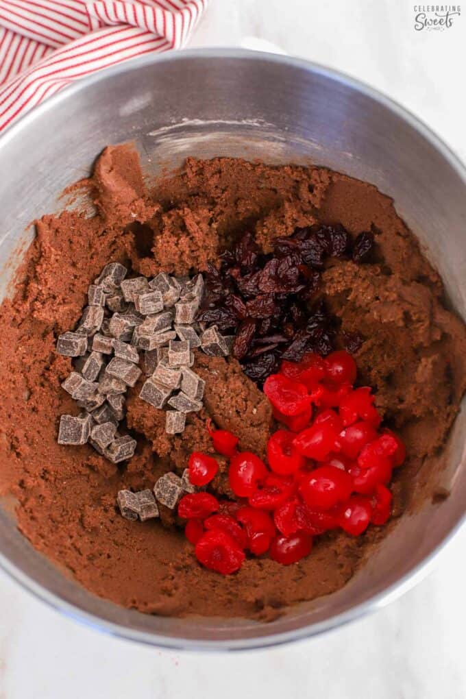 Stainless bowl filled with chocolate cookie dough, cherries, and chocolate chunks.