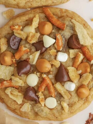 Closeup of a kitchen sink cookie topped with chocolate chips, pretzels, and chips.