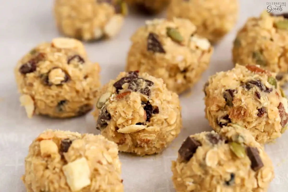 Trail mix cookie dough balls on parchment paper.