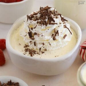 White chocolate mousse topped with whipped cream and chocolate shavings.