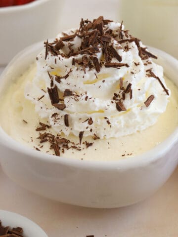 White chocolate mousse topped with whipped cream and chocolate shavings.