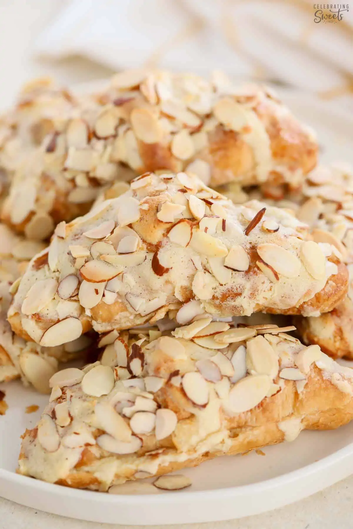 Almond croissants stacked on a plate.