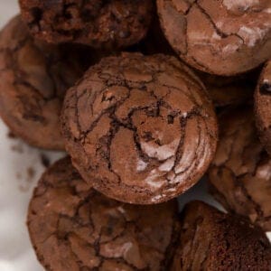 A stack of brownie bites on a white plate.