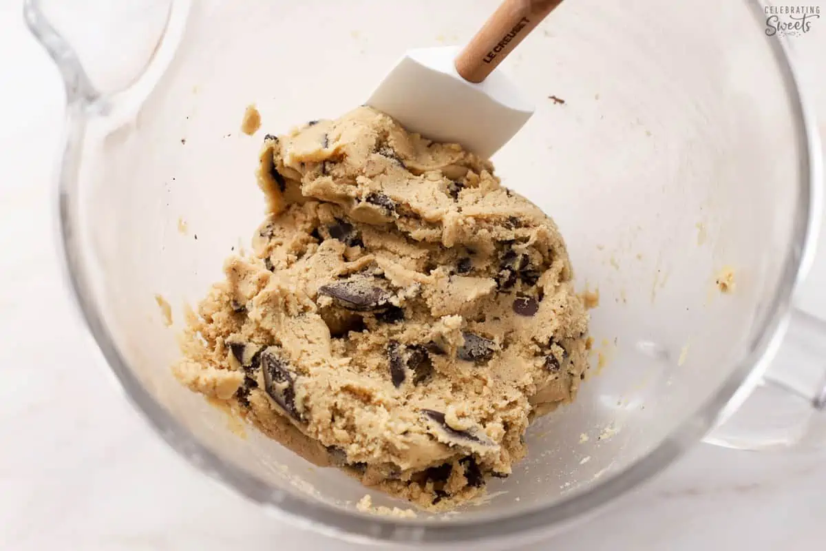 Chocolate chip cookie dough in a glass mixing bowl.