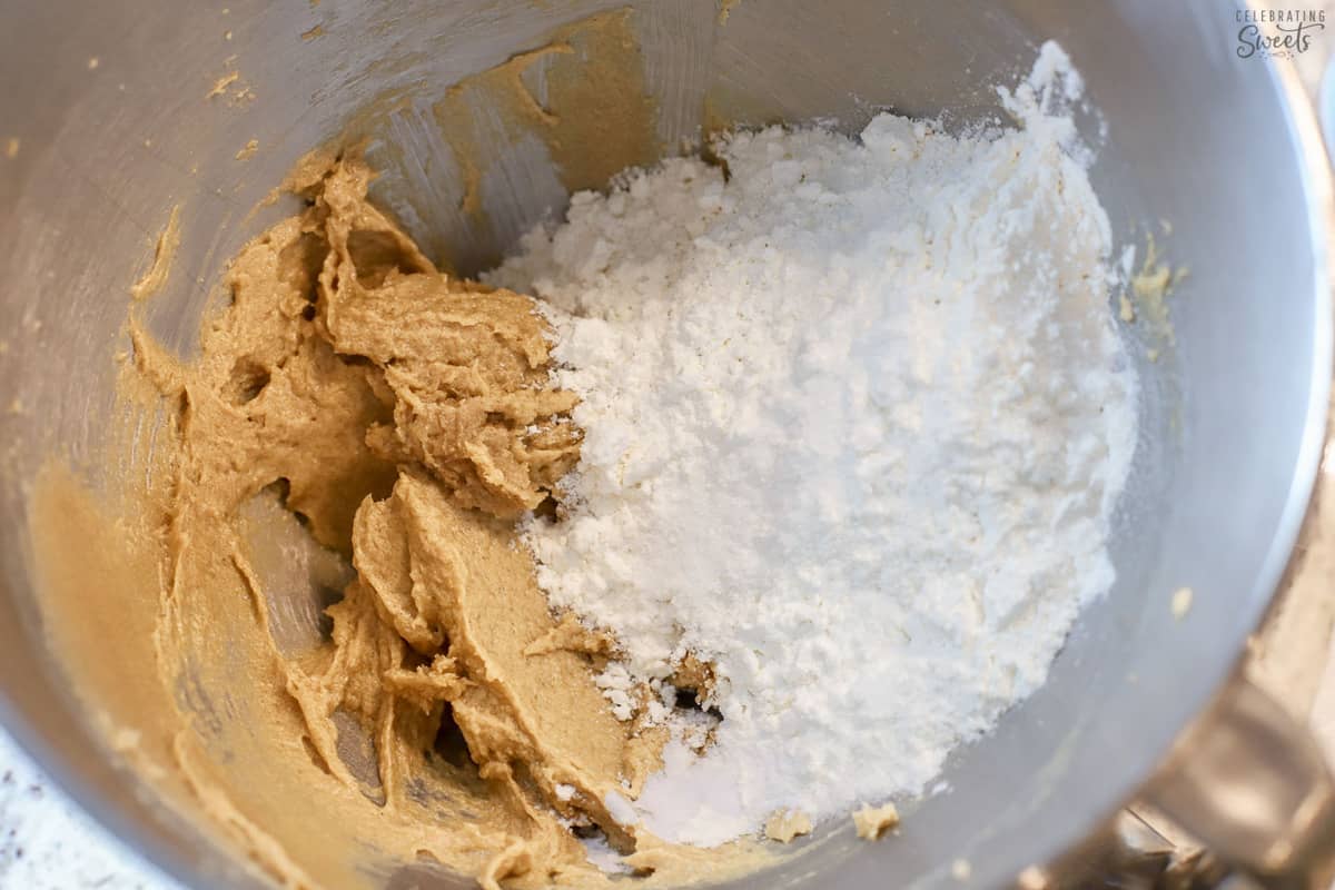 Cookie dough and flour in a stainless bowl.