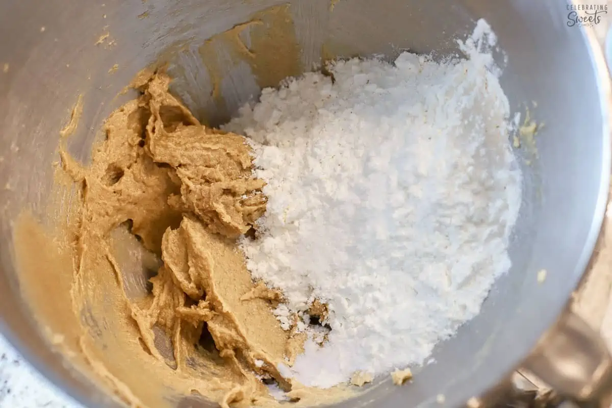 Cookie dough and flour in a stainless bowl.