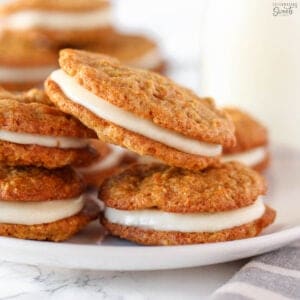 Stack of carrot cake cookies on a white plate.