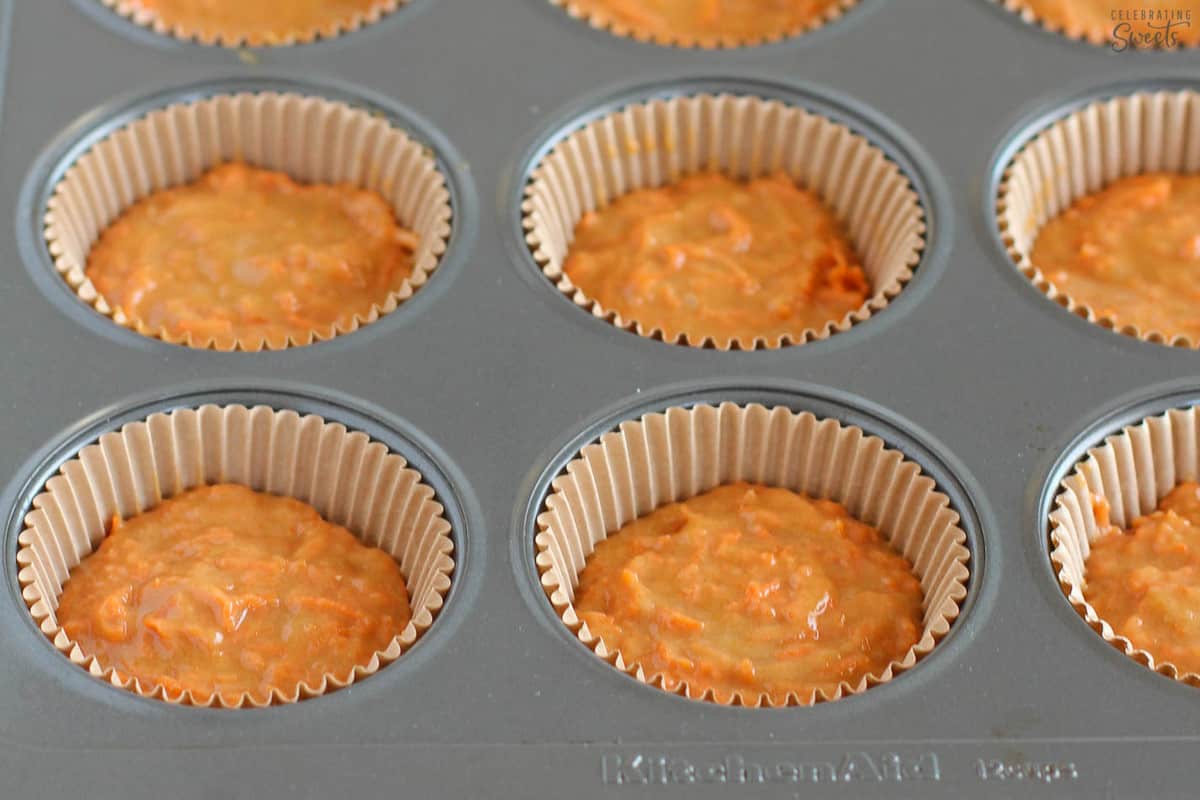 Carrot muffin batter in a muffin tin