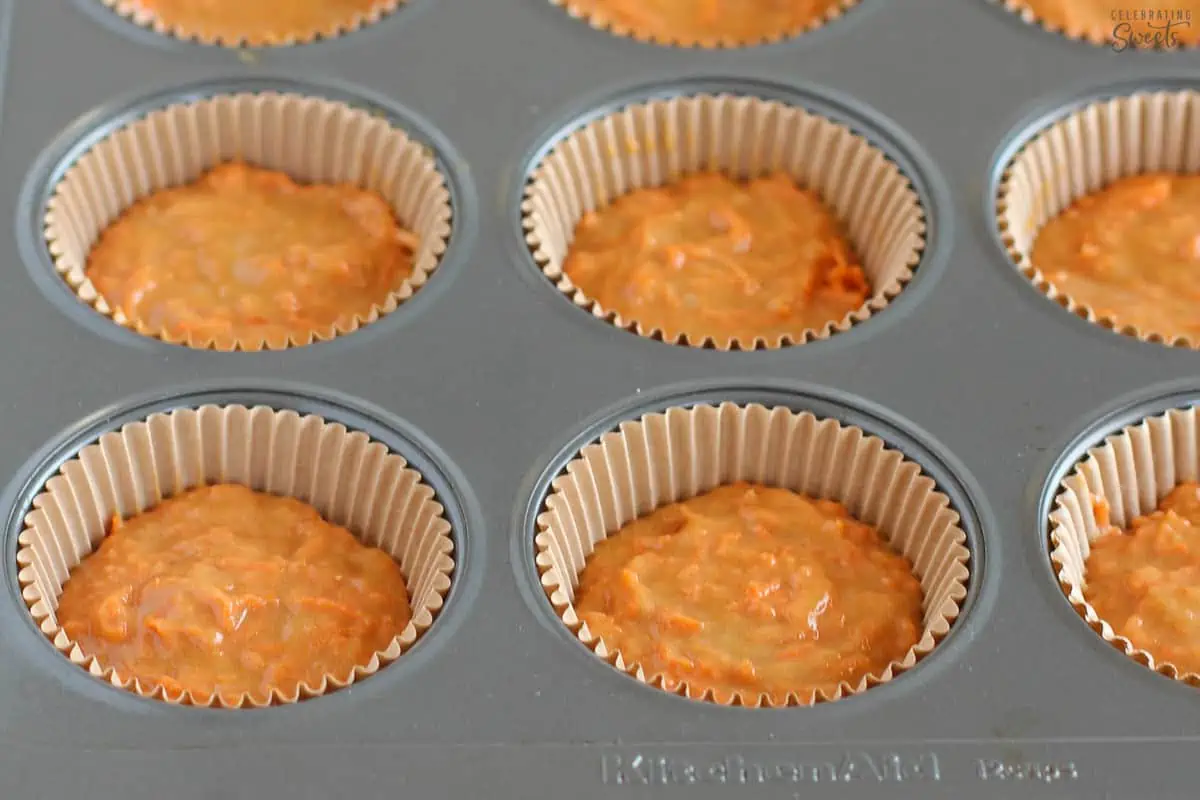 Carrot muffin batter in a muffin tin