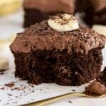 Slice of chocolate banana cake topped with chocolate shavings and sliced banana