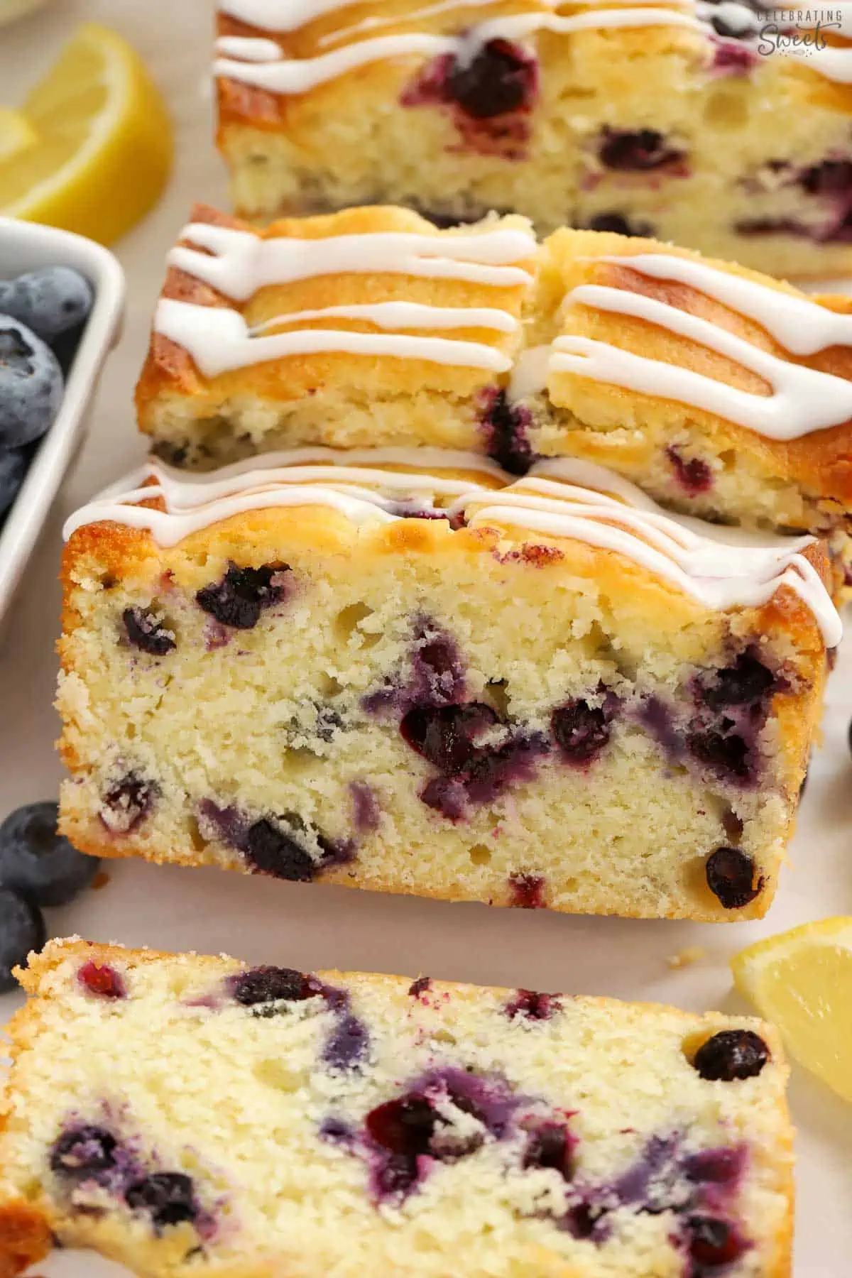 Slices of lemon blueberry bread with white icing drizzled over the top.