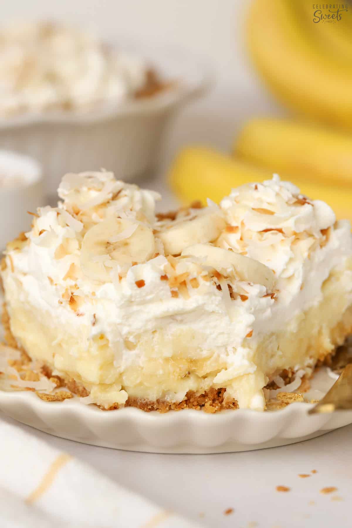 Slice of banana coconut cream pie on a white plate.