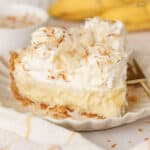 Slice of banana coconut cream pie on a white plate.