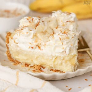 Slice of banana coconut cream pie on a white plate.