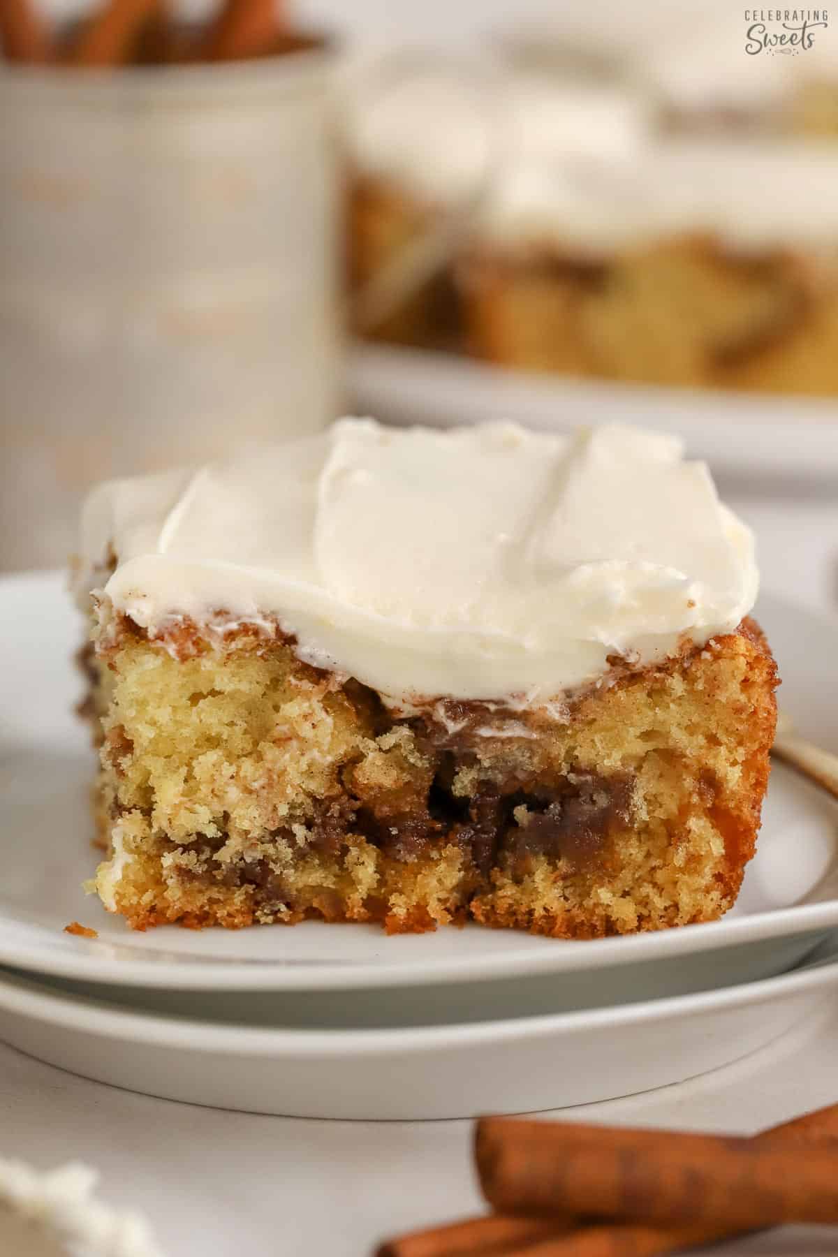 Slice of cinnamon roll cake on a white plate.