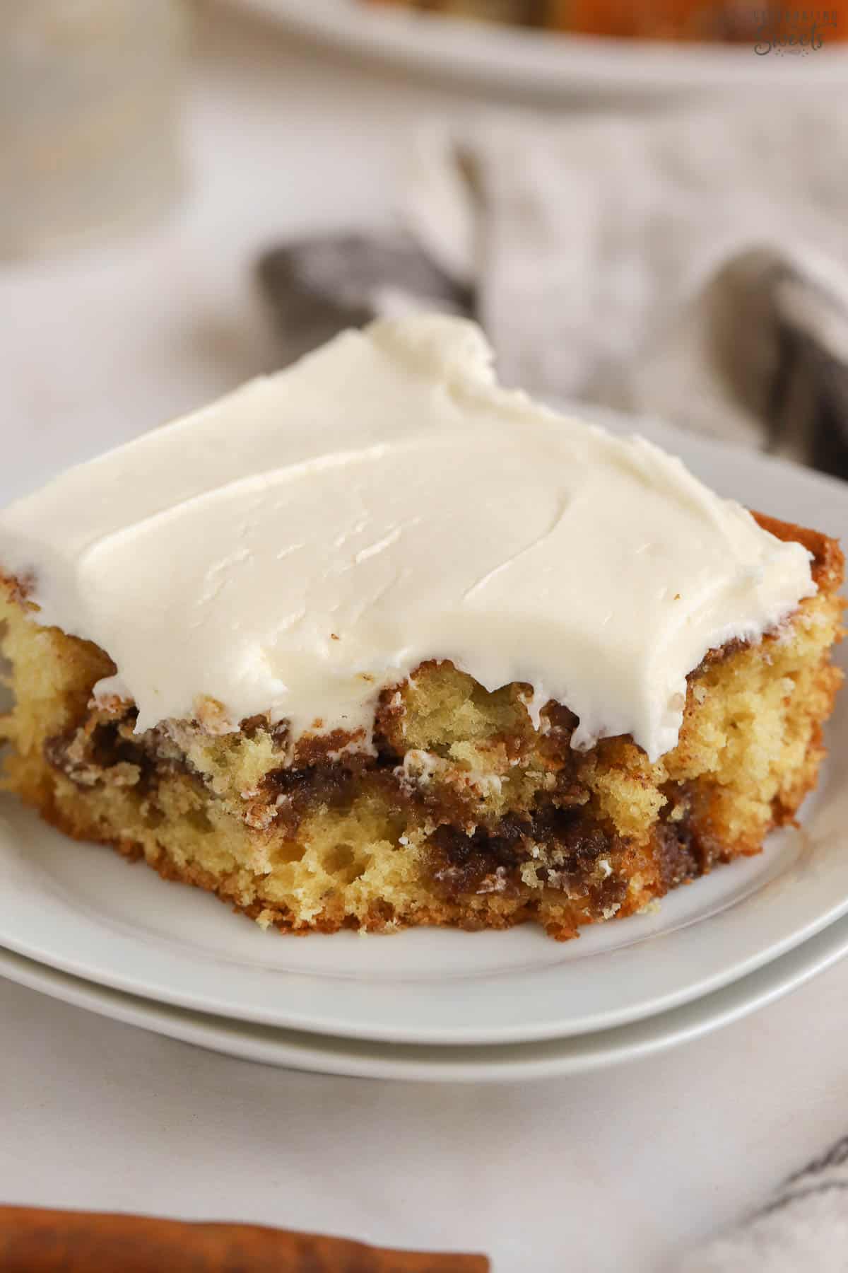 Slice of cinnamon roll cake on a white plate.
