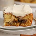 Slice of cinnamon roll cake on a white plate.