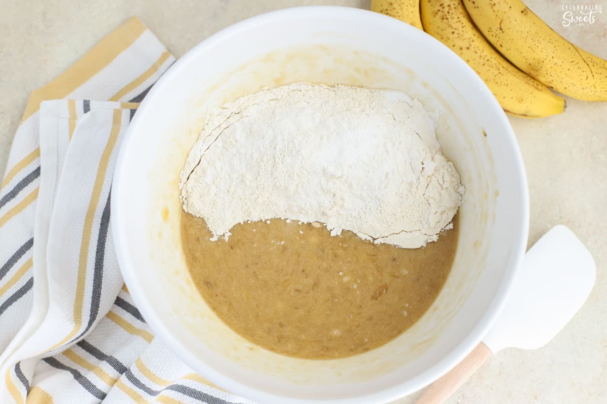 Mashed banana and flour in a white bowl.