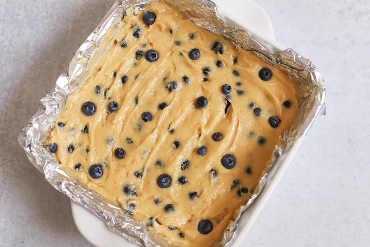 Lemon blueberry bars in a foil lined pan.