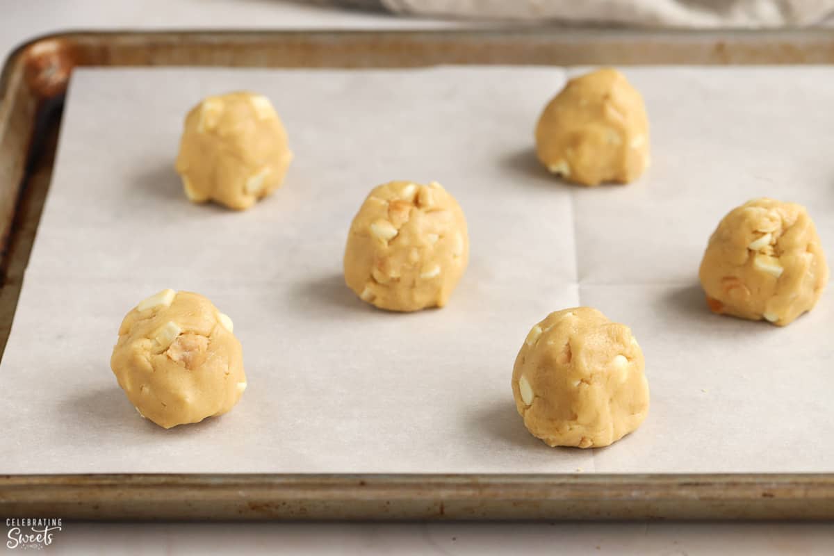 Cookie dough balls on a baking sheet.