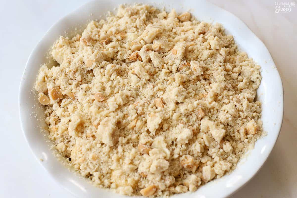 Unbaked fruit crumble in a white baking dish.