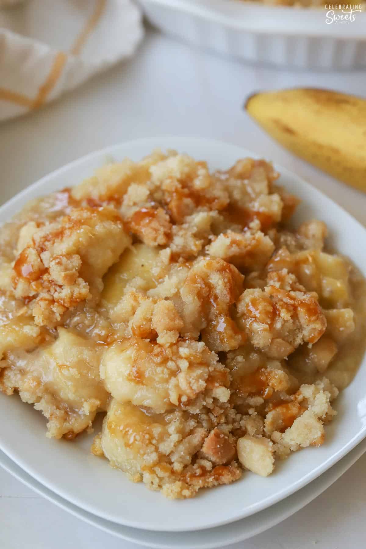 Banana crumble on a white plate topped with caramel.