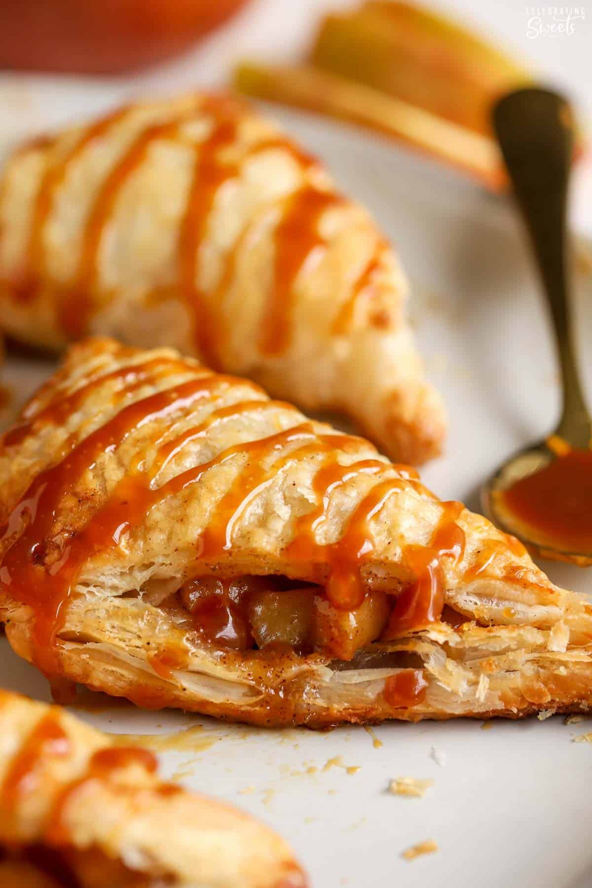 Closeup of an apple turnover drizzled with caramel sauce.