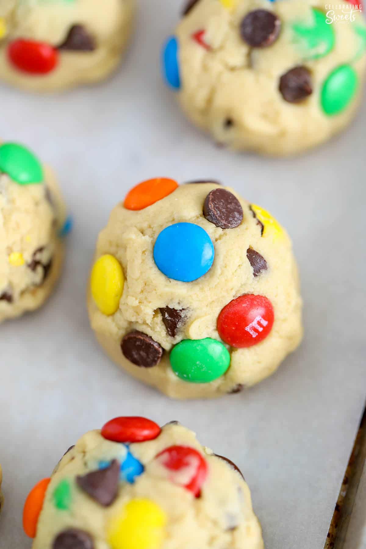 Cookie dough ball covered in M&M's and chocolate chips.