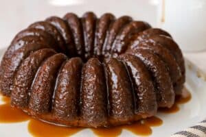 Sticky toffee pudding bundt cake on a white plate.