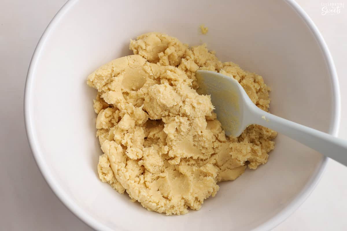 Sugar cookie dough in a white bowl.