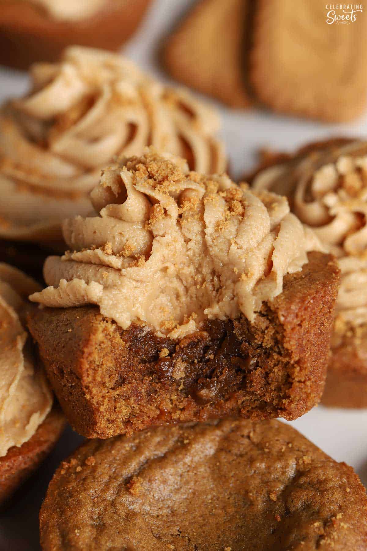Gingerbread cookie cup topped with light brown frosting with a bite taken out of it.