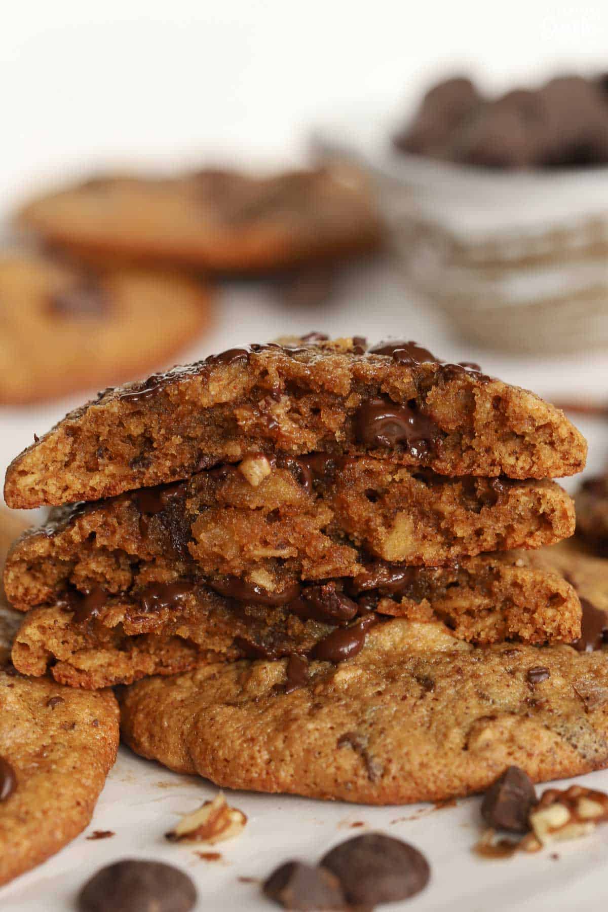 Stack of three pieces of chocolate chip cookies on parchment paper.
