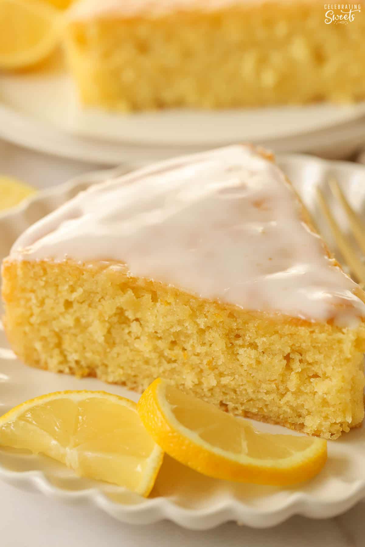 Slice of lemon olive oil cake topped with white icing.
