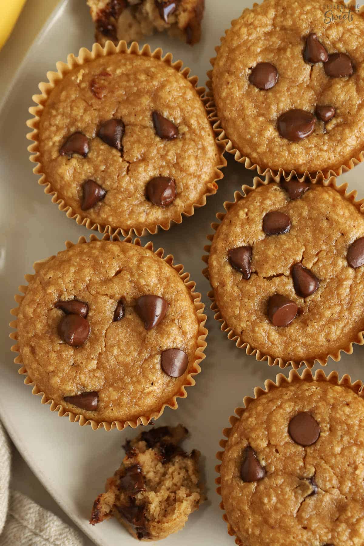 Banana oatmeal muffins topped with chocolate chips on a grey plate,