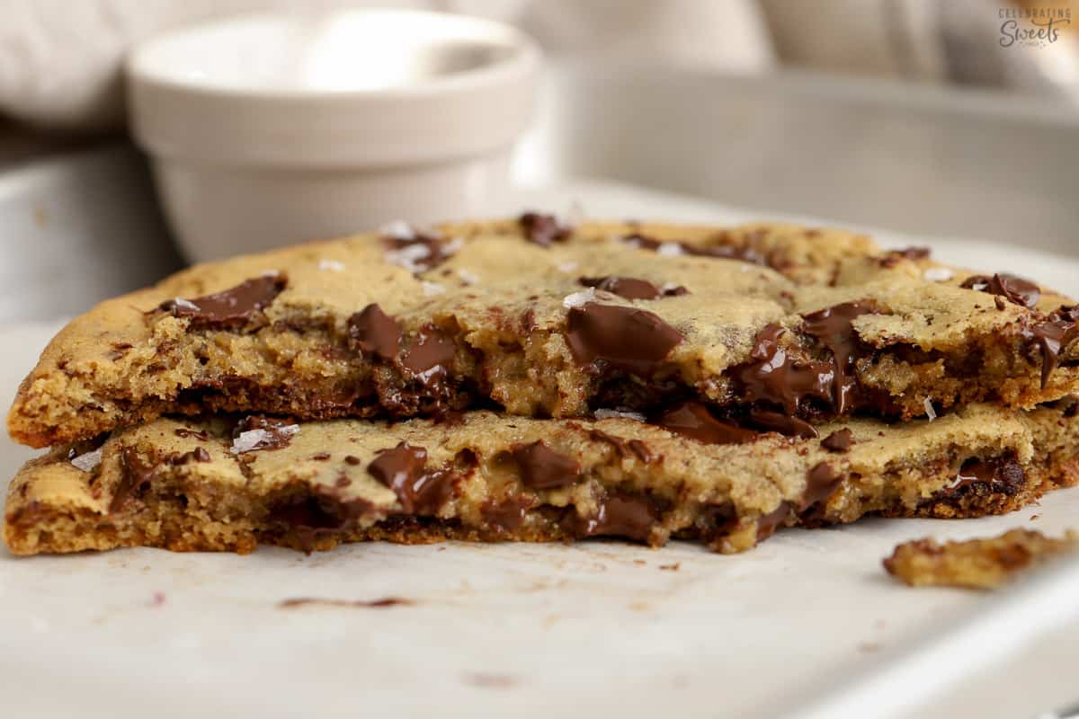Two halves of a chocolate chip cookie stacked on top of each other.