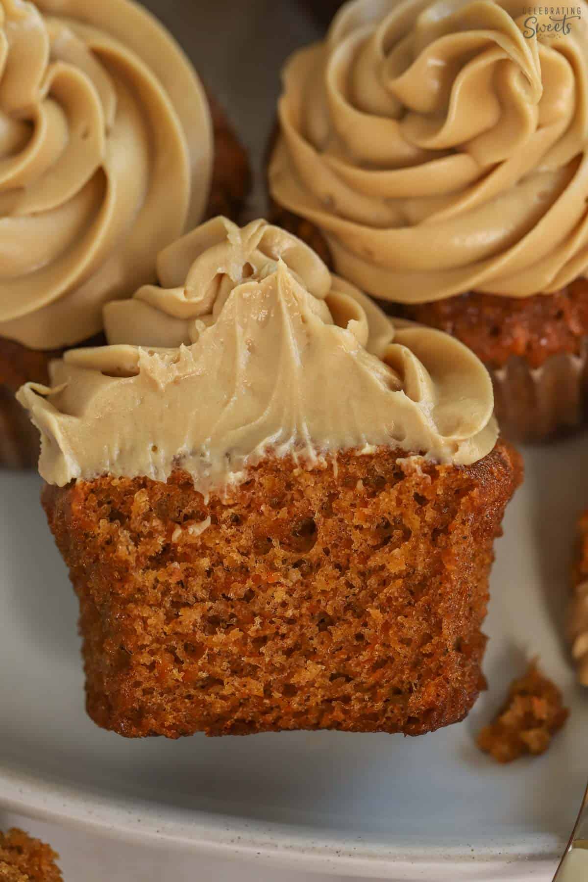 Carrot cake cupcake cut in half on a grey plate.