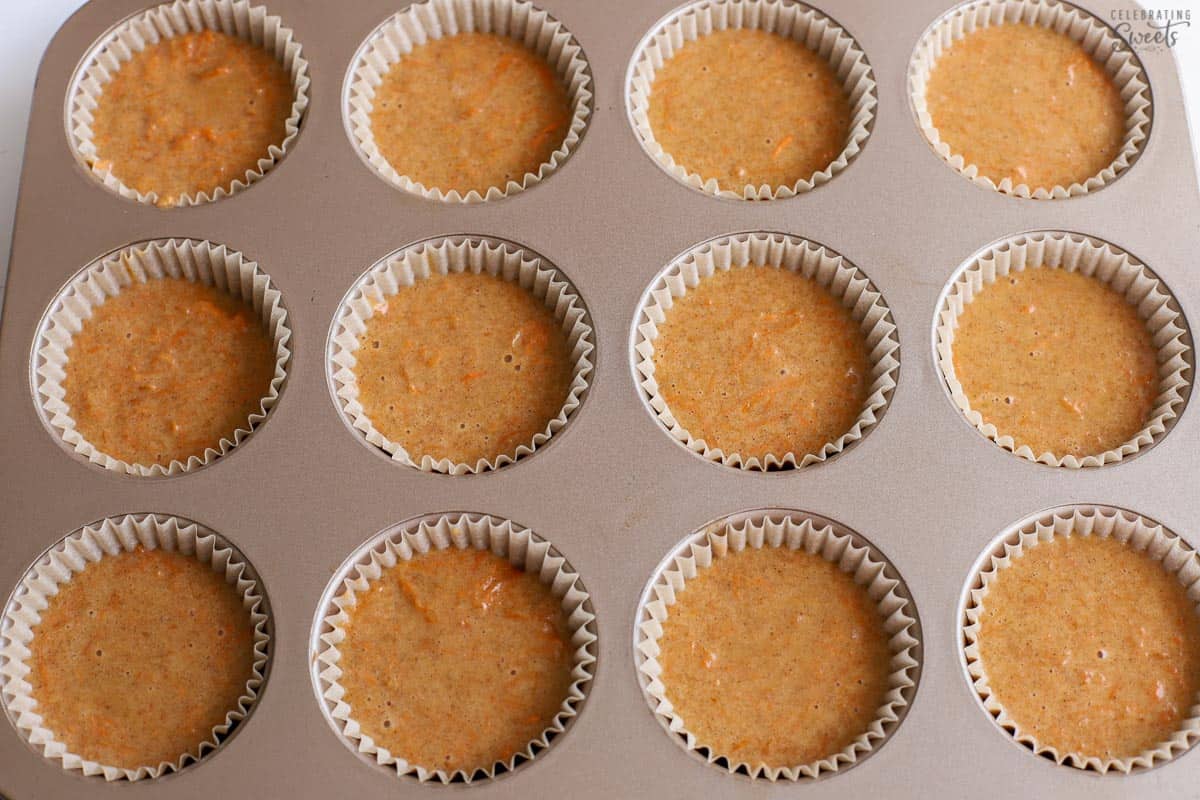Carrot cake cupcake batter in a muffin pan.