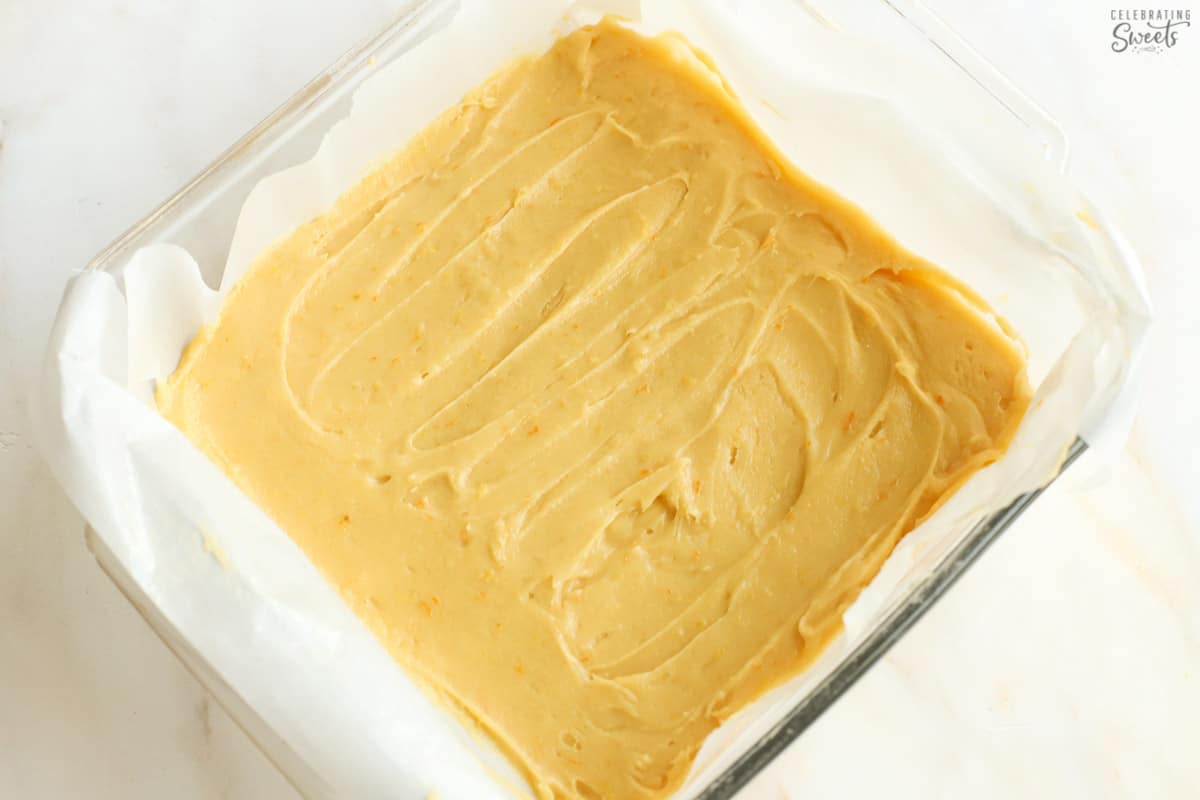 Batter for raspberry lemon bars in a parchment lined baking pan.