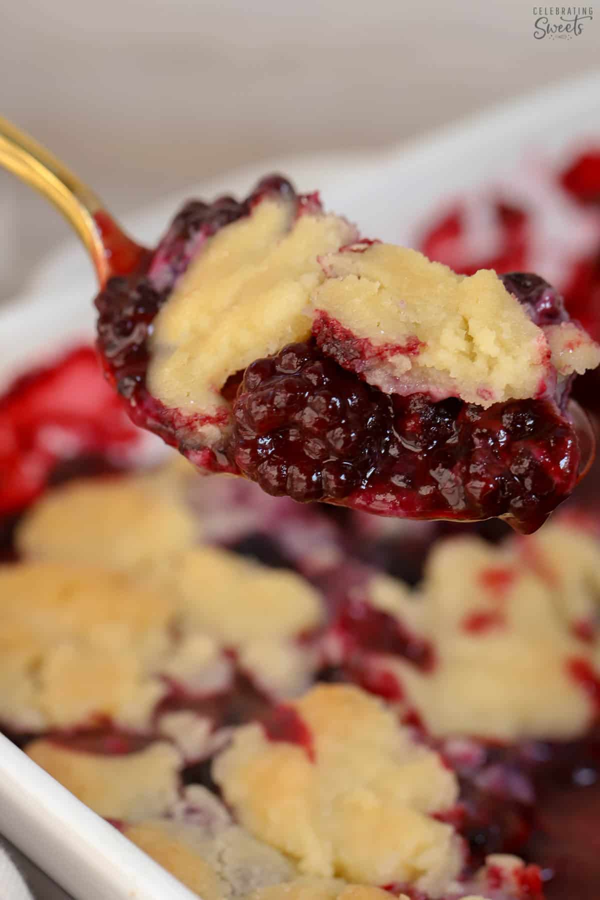 Scoop of blackberry cobbler on a gold spoon.