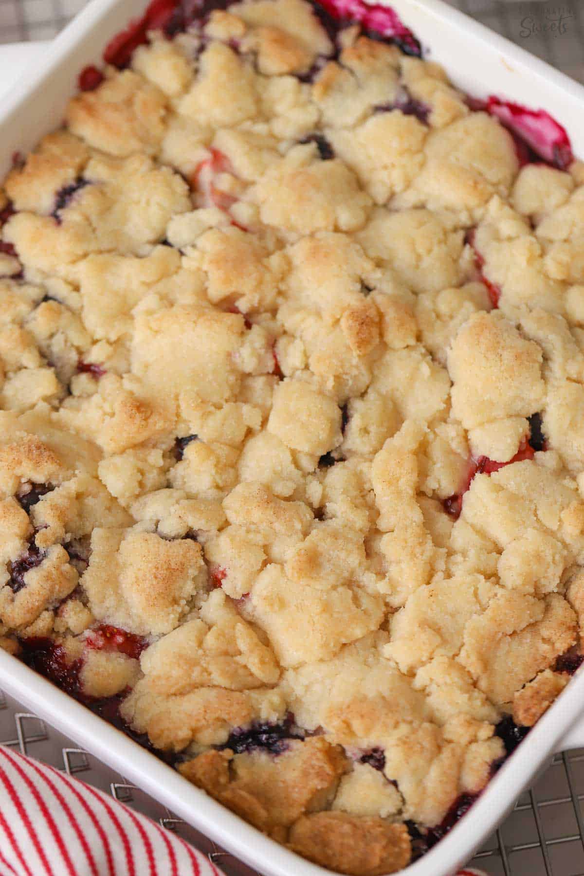 Blackberry cobbler in a white baking dish.