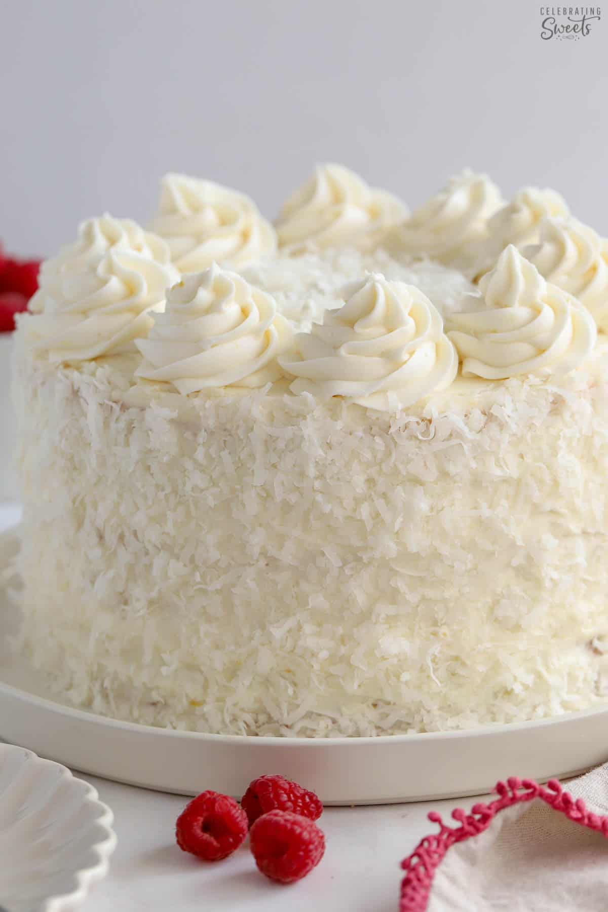 White cake topped with vanilla buttercream frosting on a white plate.