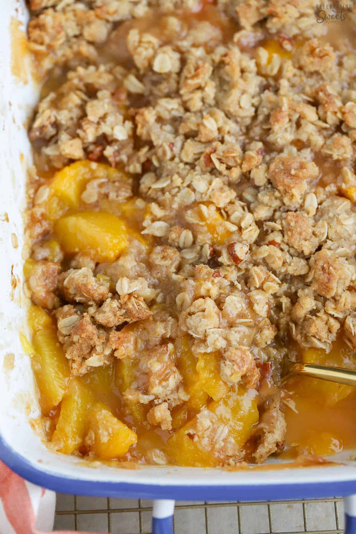 Peach crisp in a white and blue casserole dish.