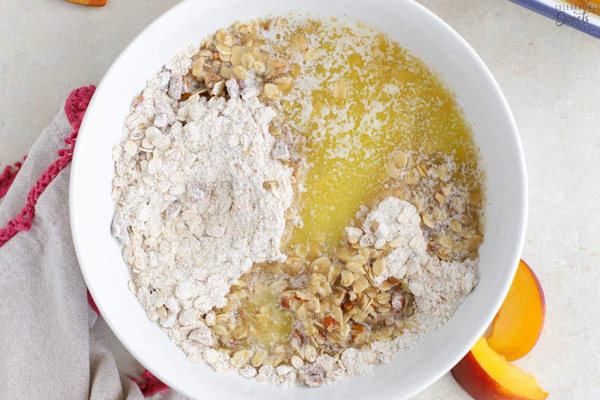 Bowl of peach crisp topping (oats, flour, pecans, melted butter).