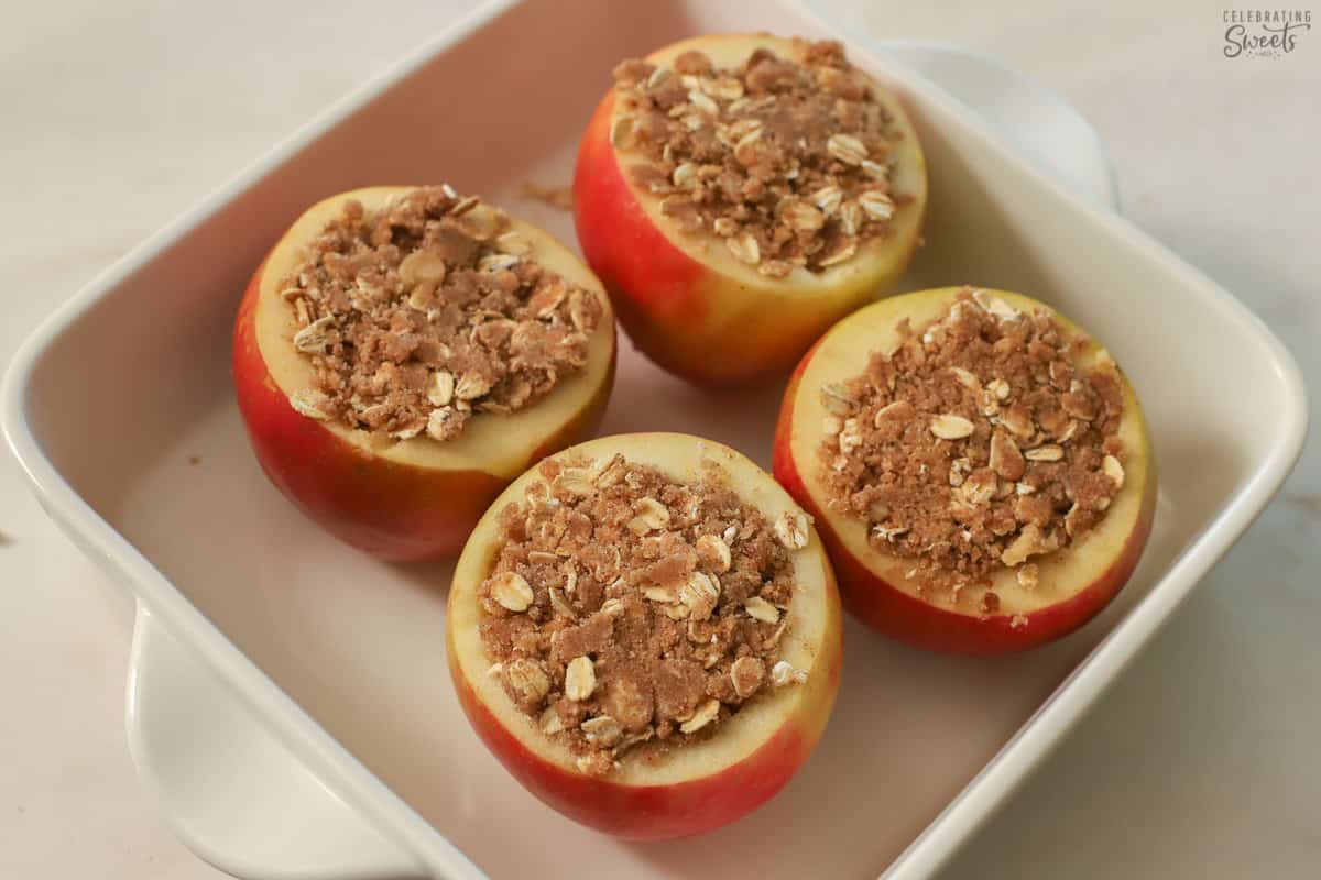 Baked apples in a white square baking dish.